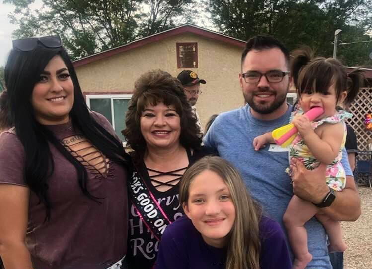 An image of a family standing together smiling for a photo at a get together.