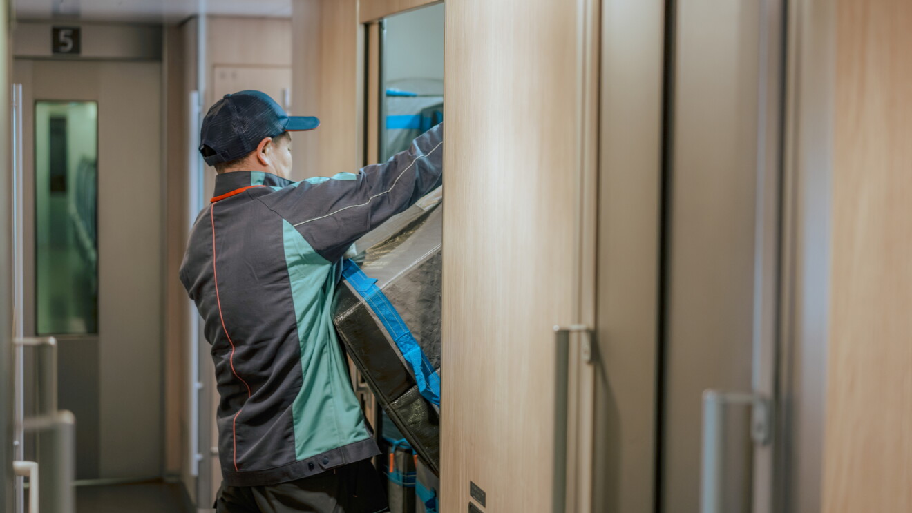 Delivery person carrying packages in train corridors