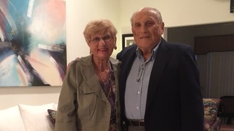 An image of Dan and his wife smiling for a photo in their living room.