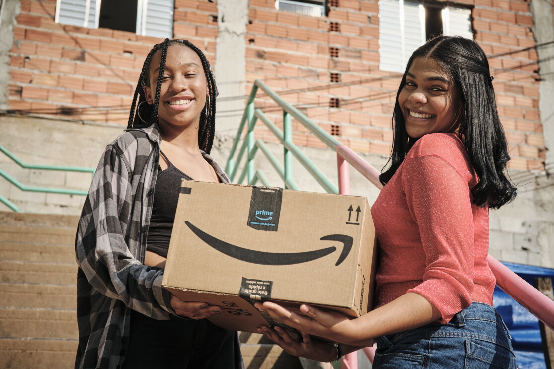 Mulheres seguram caixas da Amazon Prime em Paraisópolis
