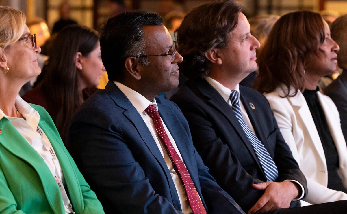 A photo of AWS Vice President Swami Sivasubramanian sitting in the audience listening to a presentation at an U.N. summit on generative AI.