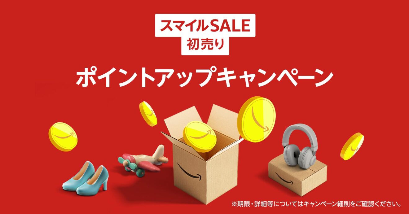 2025年Amazon初売り「スマイルSALE」のポイントアップキャンペーン告知画像。中央にAmazonロゴ入りの段ボール箱があり、そこから黄色いAmazonコインが飛び出している。箱の周りには飛行機の模型、ハイヒール、ヘッドホンといった商品が配置されている。