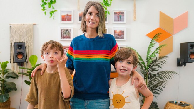 一位母亲和她的两个儿子的照片在相机在起居室里微笑。