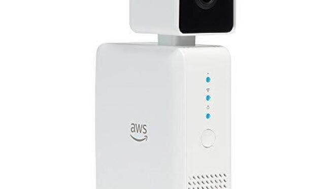 组成的装置,一个白盒子顶着一个相机在一个方形外壳。亚马逊网络服务的标志是。”width=