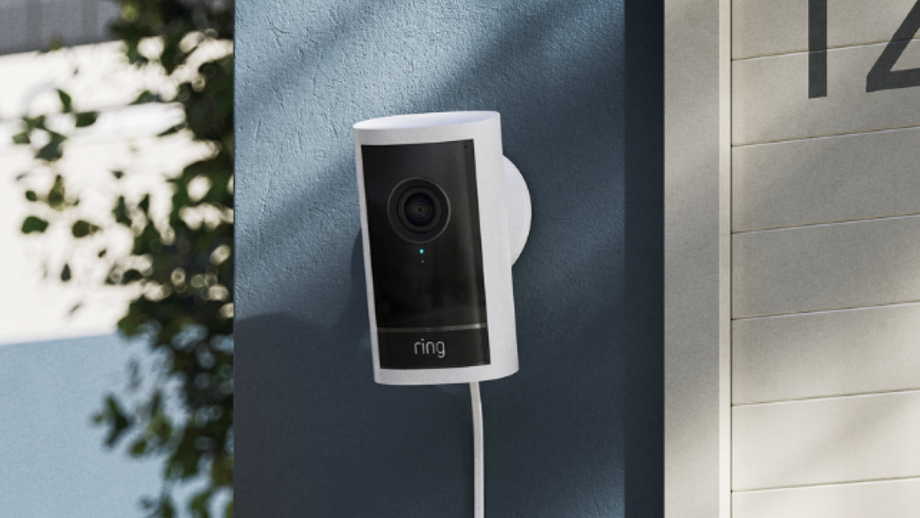 Smart home security device installed next to greenery and house number
