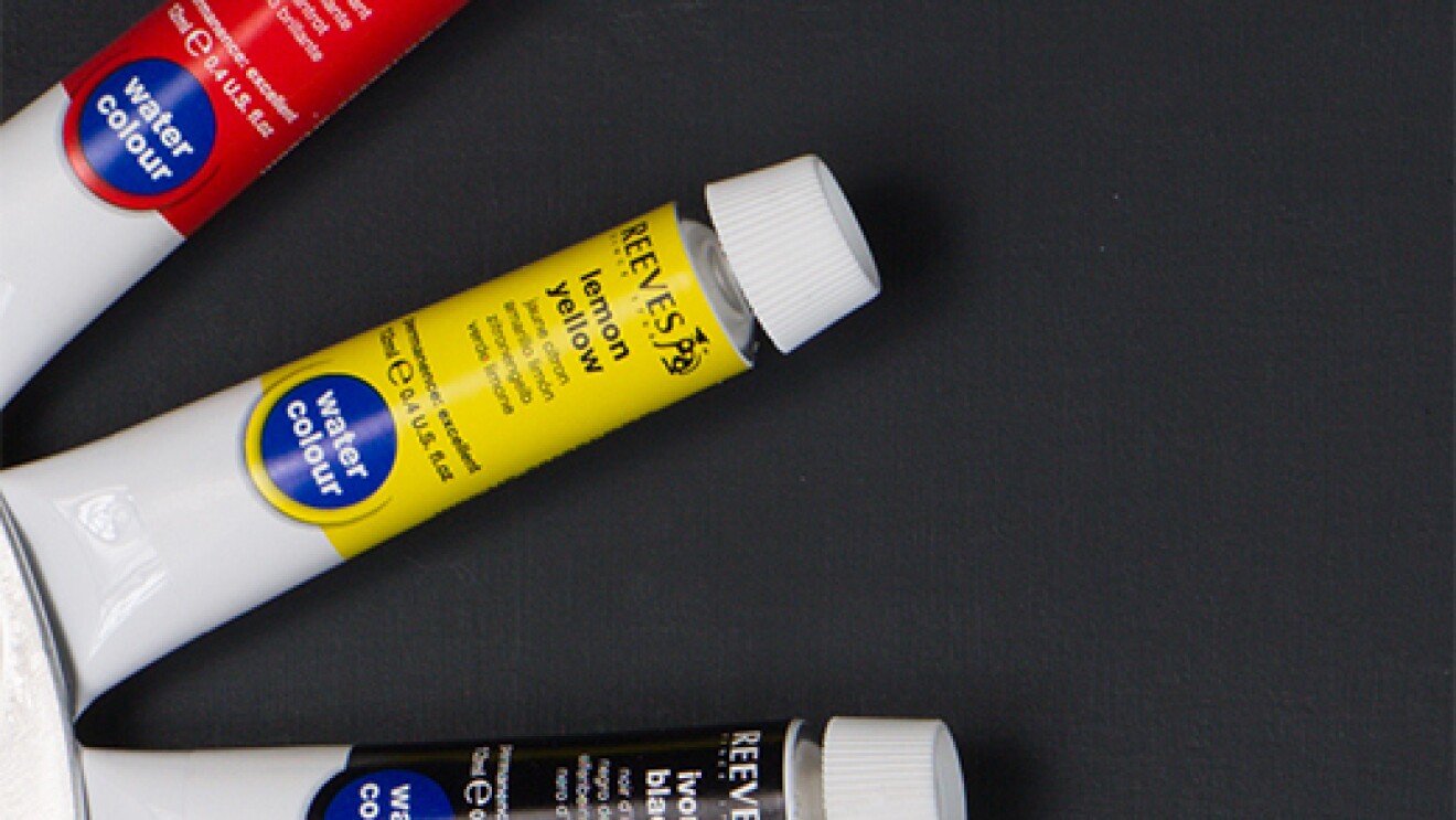 Three tubes of paint are arranged in a radial pattern. The top tube is labeled "brilliant red." The middle is "lemon yellow." The bottom is "ivory black."