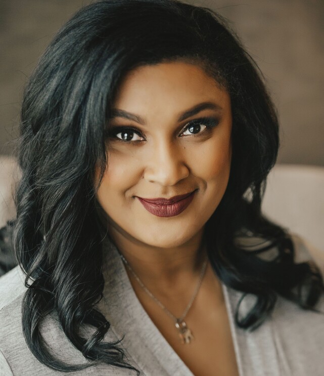 Woman smiles at the camera, in a headshot
