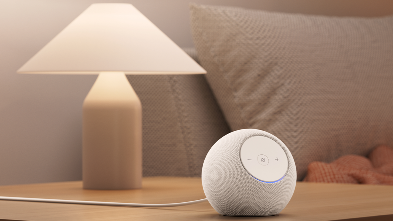 Enceinte intelligente sur une table de chevet à côté d'une lampe