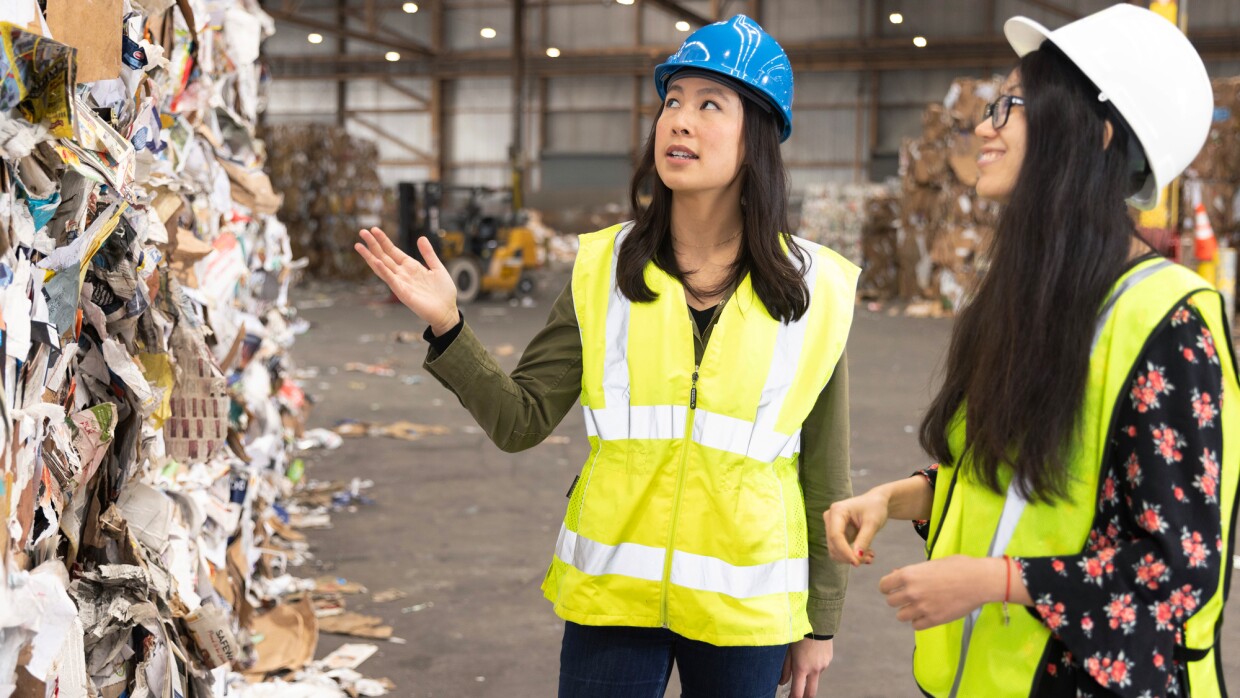 Two women stand at a recycling centre