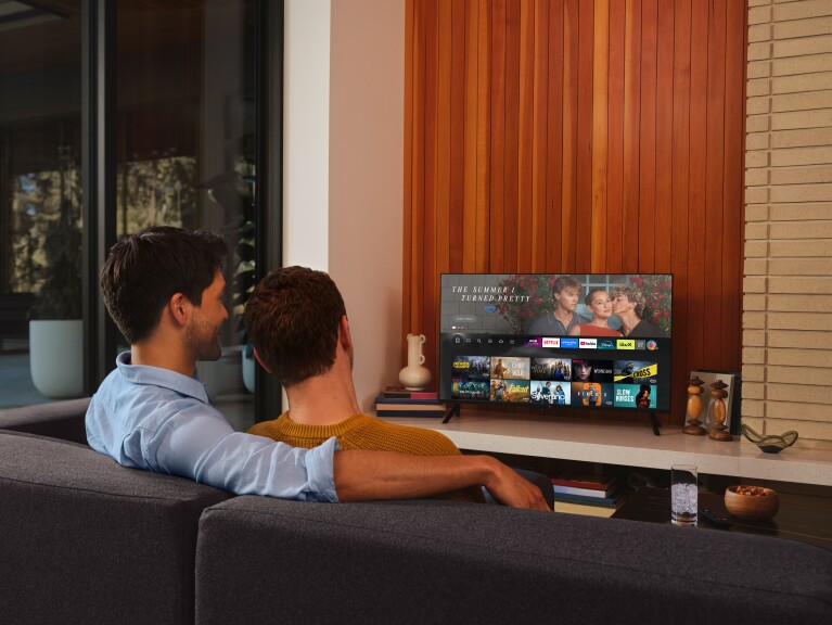 A couple sit on the sofa ready to watch fire TV