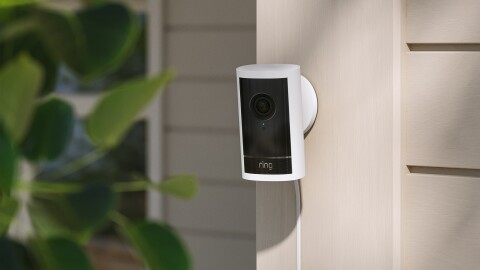 Ring video doorbell mounted on exterior wall near greenery