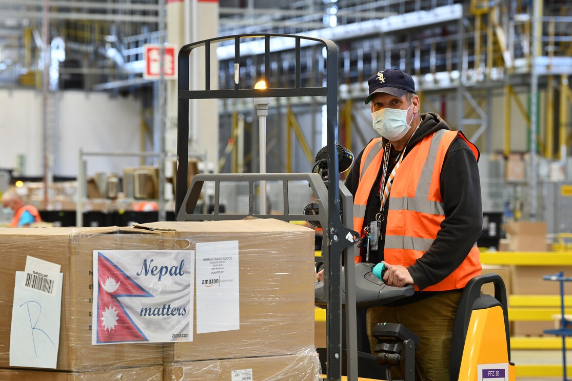 Amazon employees work together inside a fulfillment center in Germany to gather supplies for disaster relief aid to Nepal.