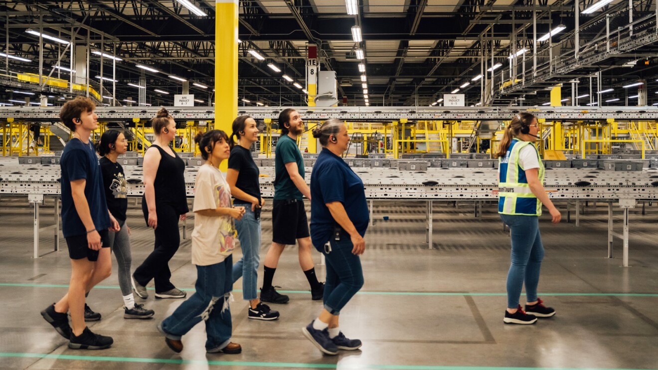 Amazon employees giving a tour of a fulfillment center.