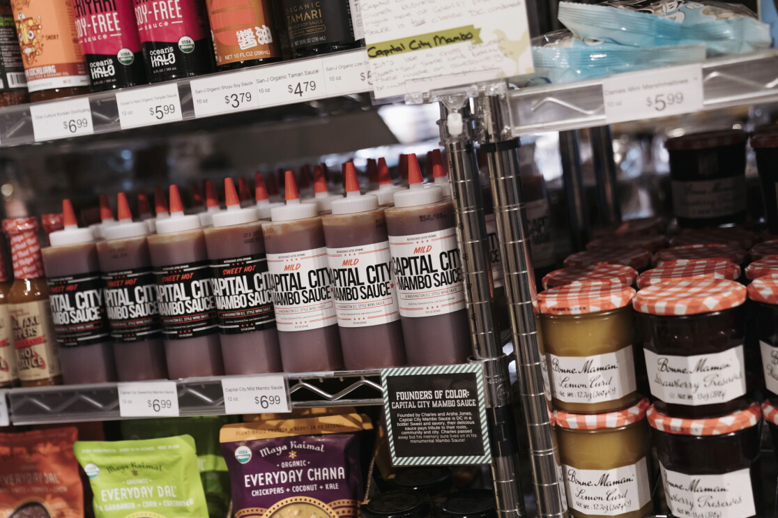 Capital City Mambo Sauce sits on the shelf of a retailer alongside other grocery products.