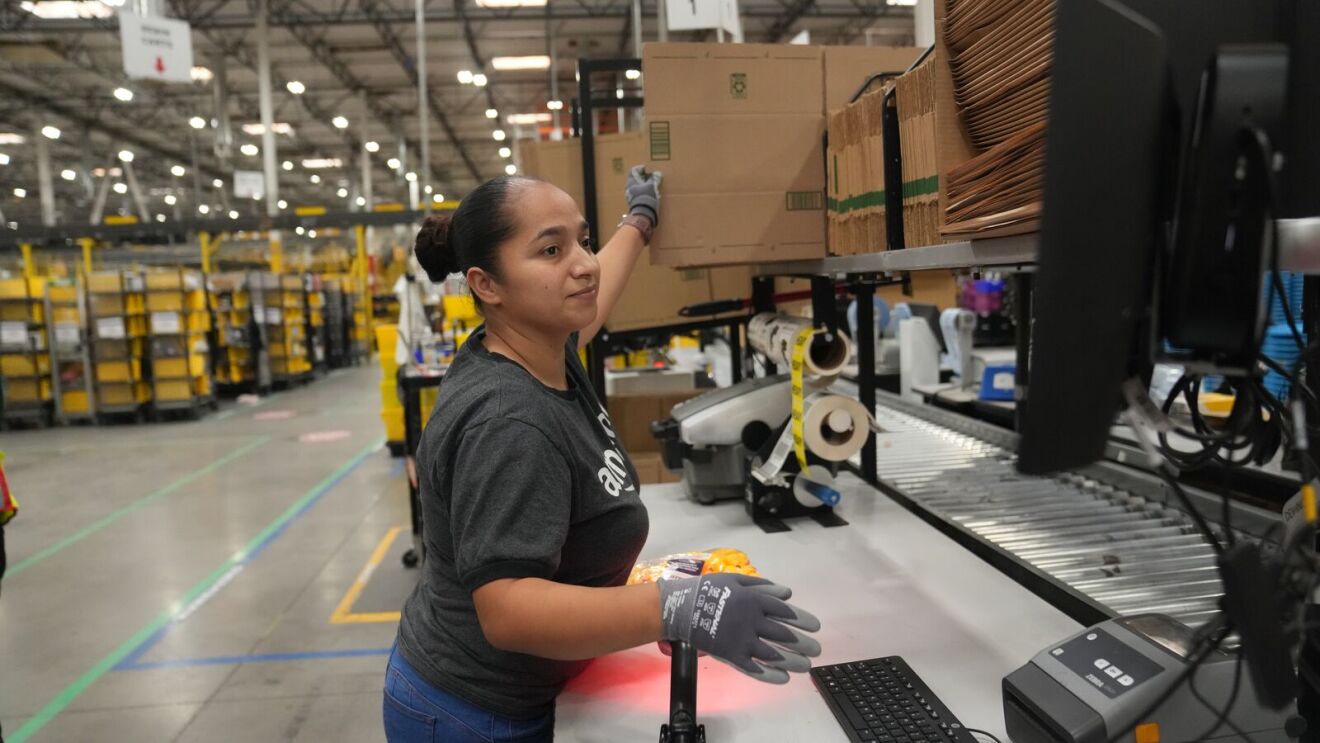 Employee in Amazon shirt organizing boxes