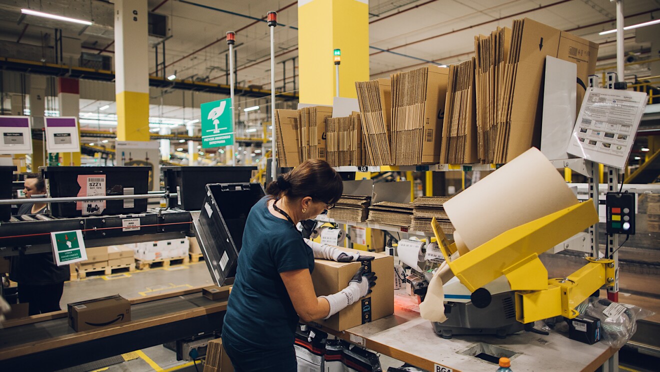 Un employé d'Amazon emballant un produit