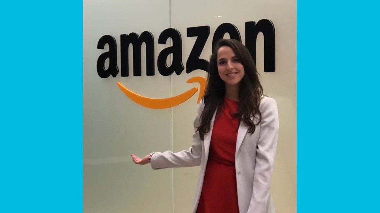 Meet Amazon employees making Alexa more accessible 24 Juliana smiling while standing in front of a glass wall that says Amazon on it.