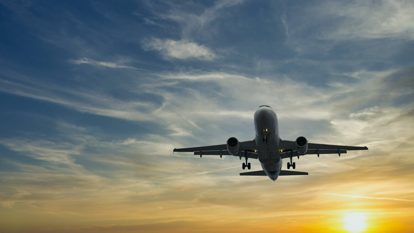 The plane against the blue sunset sky. Picture of the setting sun