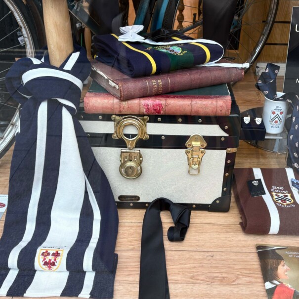 University graduation package display with gown, cap, books, and accessories