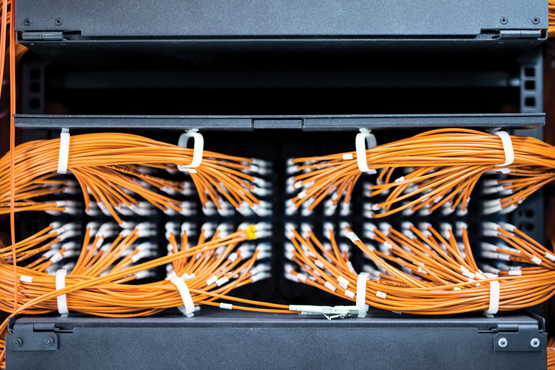 A collection of secured, orange AWS server cables.