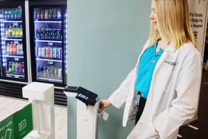 A photo of a hospital employee scanning their badge using Just Walk Out technology to enter a hospital retail store.