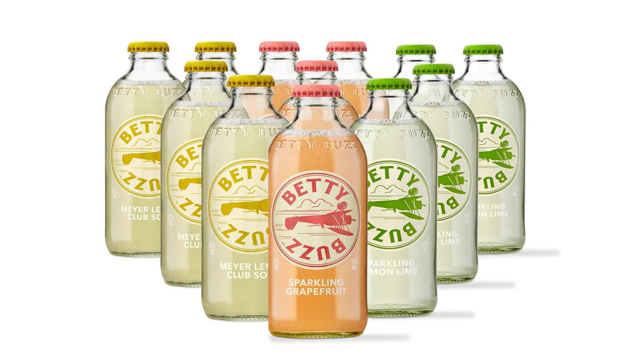 An image of multiple glass bottles set in a pyramid formation. They have various liquid colors inside, and a logo on the front that says "Betty Buzz"