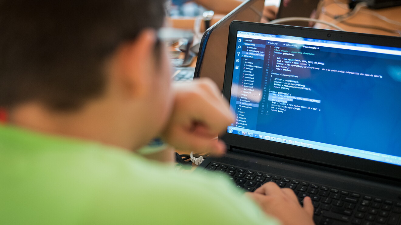 An image of a young man programming on a computer.