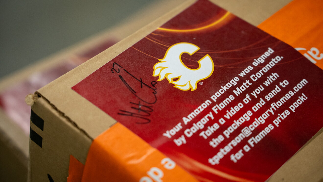 Two Calgary Flames hockey players packing and shipping Amazon boxes