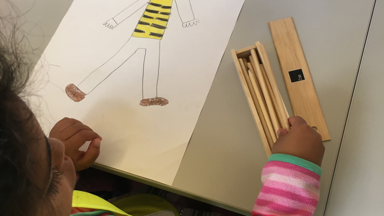 The drawing of one of the kids, about a man wearing yellow vest and glasses. 