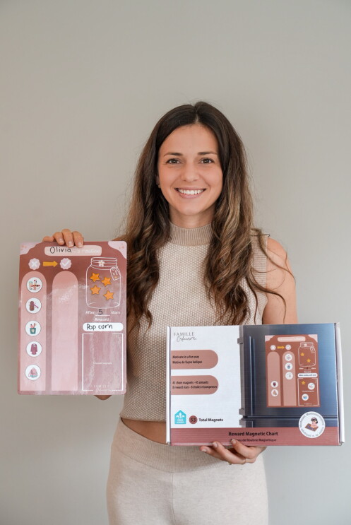 Un fondatrice de Kangoo et Cie tenant des produits et souriant