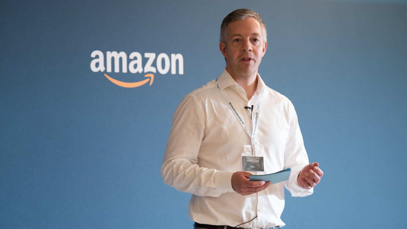 Graeme Smith, Managing Director, Amazon Development Center Scotland,  moderatore dell'evento European Innovation Day. Sullo sfondo, il logo Amazon