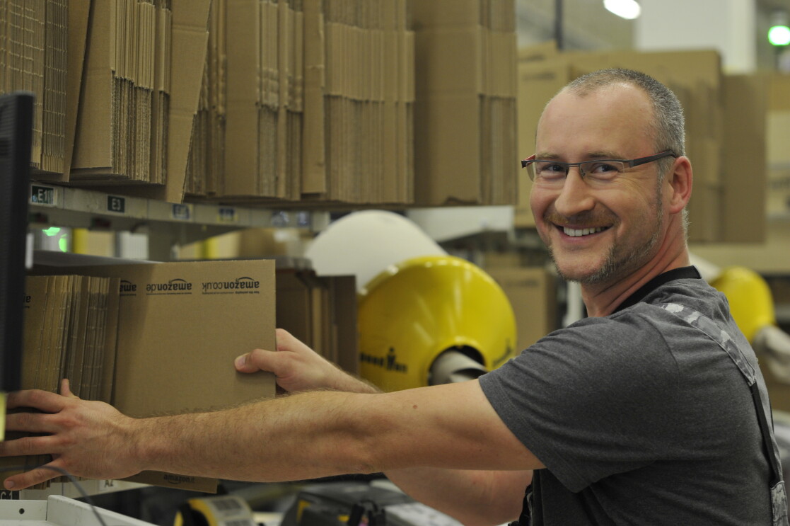 Ein Mitarbeiter im Logistikzentrum an einer Packstation