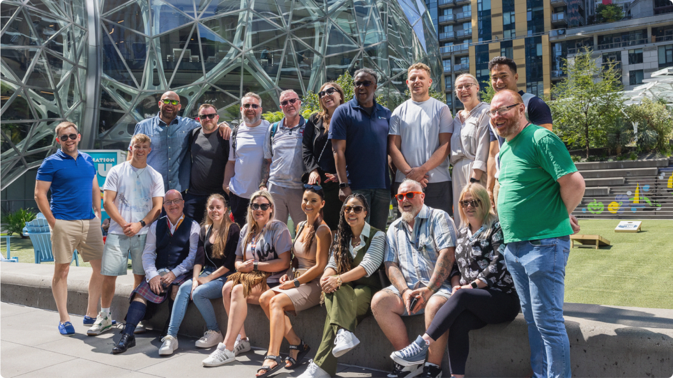 Group of Amazon employees in casual wear in front of Seattle HQ