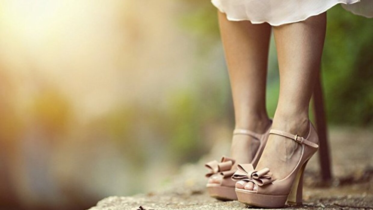 Une paire chaussures et le bas d'une robe portées par une personne qui se tient sur un rocher