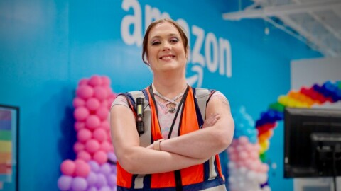 特里克西穿着橙色的安全背心,站在气球前,双手交叉微笑。