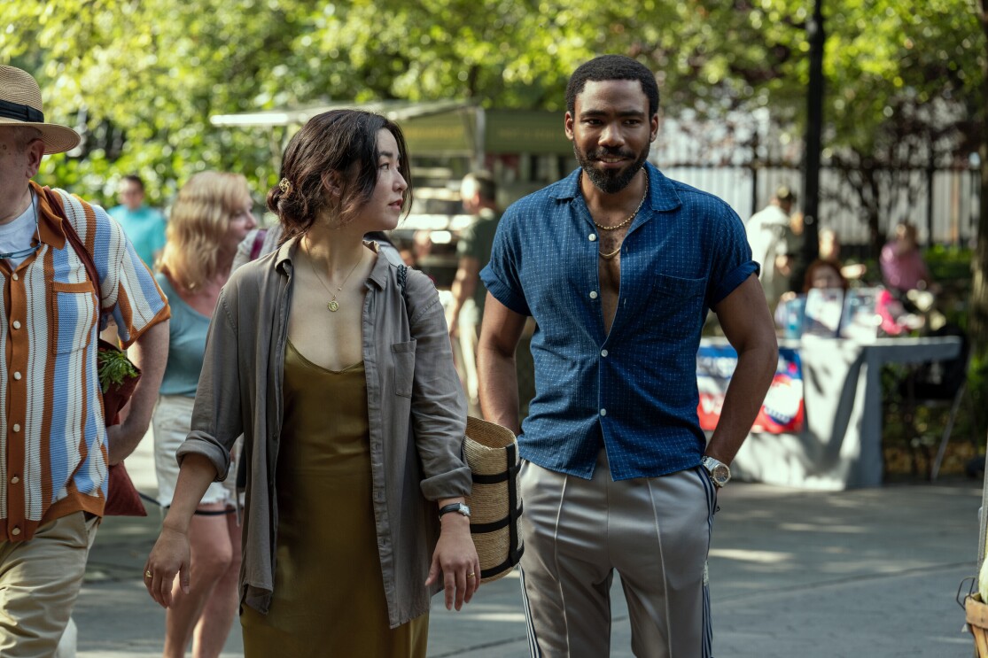 A man and a woman waking side by side in a bustling market