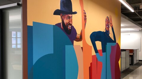 在亚马逊丹佛办公室,两个人微笑着写字的壁画图片。