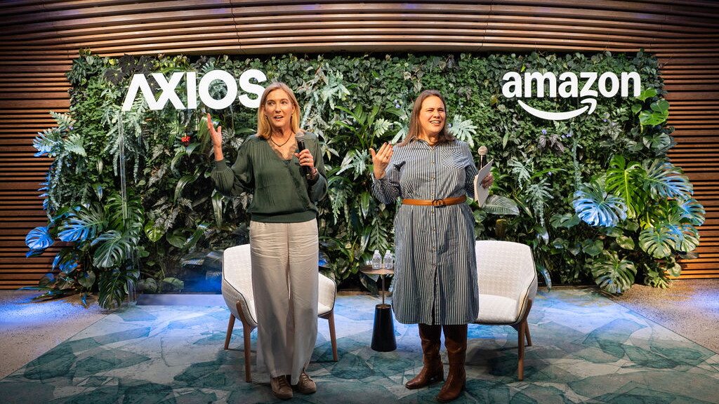 xTwo women presenting at AXIOS and Amazon event in front of living plant wall backdrop