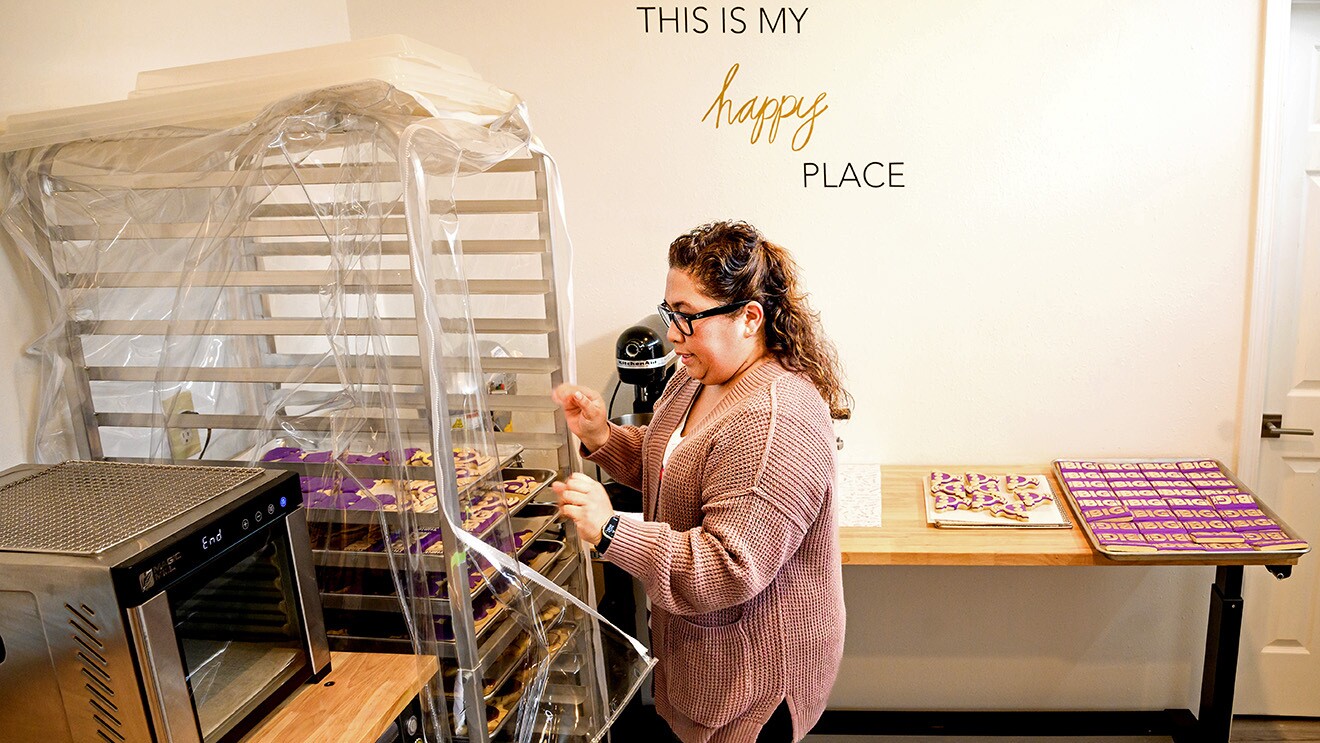 A photo of a baker inspecting cookies on a cooling rack.