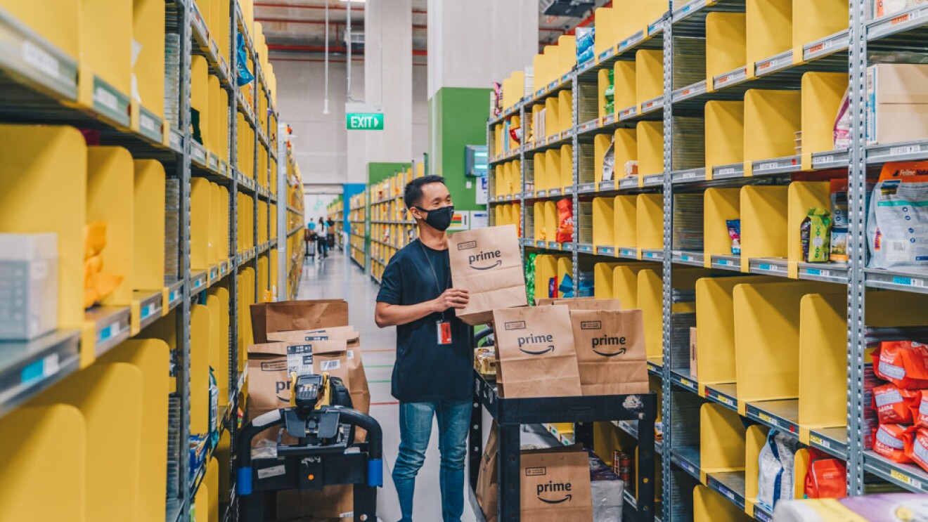 An employee packing multiple Amazon Fresh orders