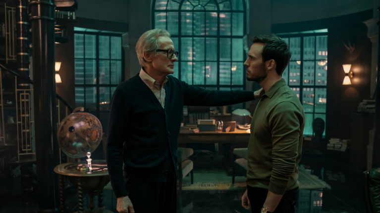 Two men in intense conversation in stylish office with city view