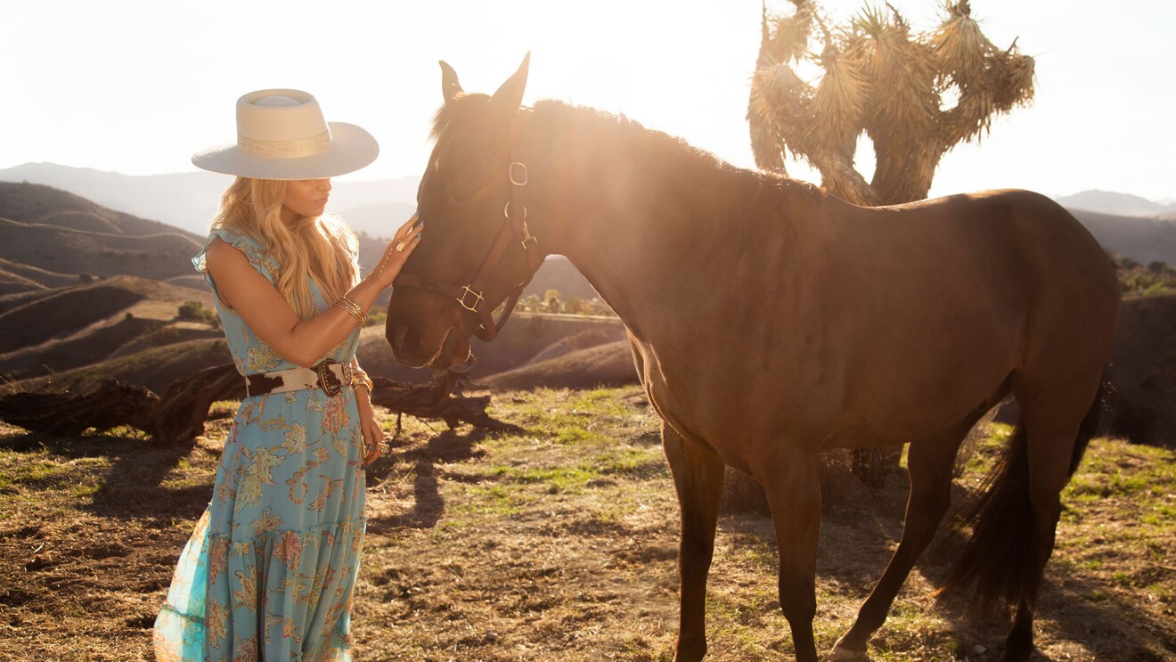 杰西卡·辛普森(歌手、演员、作家)站在一个字段女牛仔靴,穿一件衣服,和皮带,因为她的宠物马在枪口促销形象