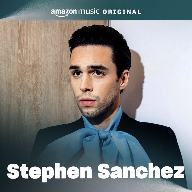 The album cover for Stephen Sanchez's song. It features a portrait of Stephen standing in front of a white wall and looking off into the distance behind the camera. He is wearing a black top with a blue, thin scarf wrapped into a bow around his neck. 