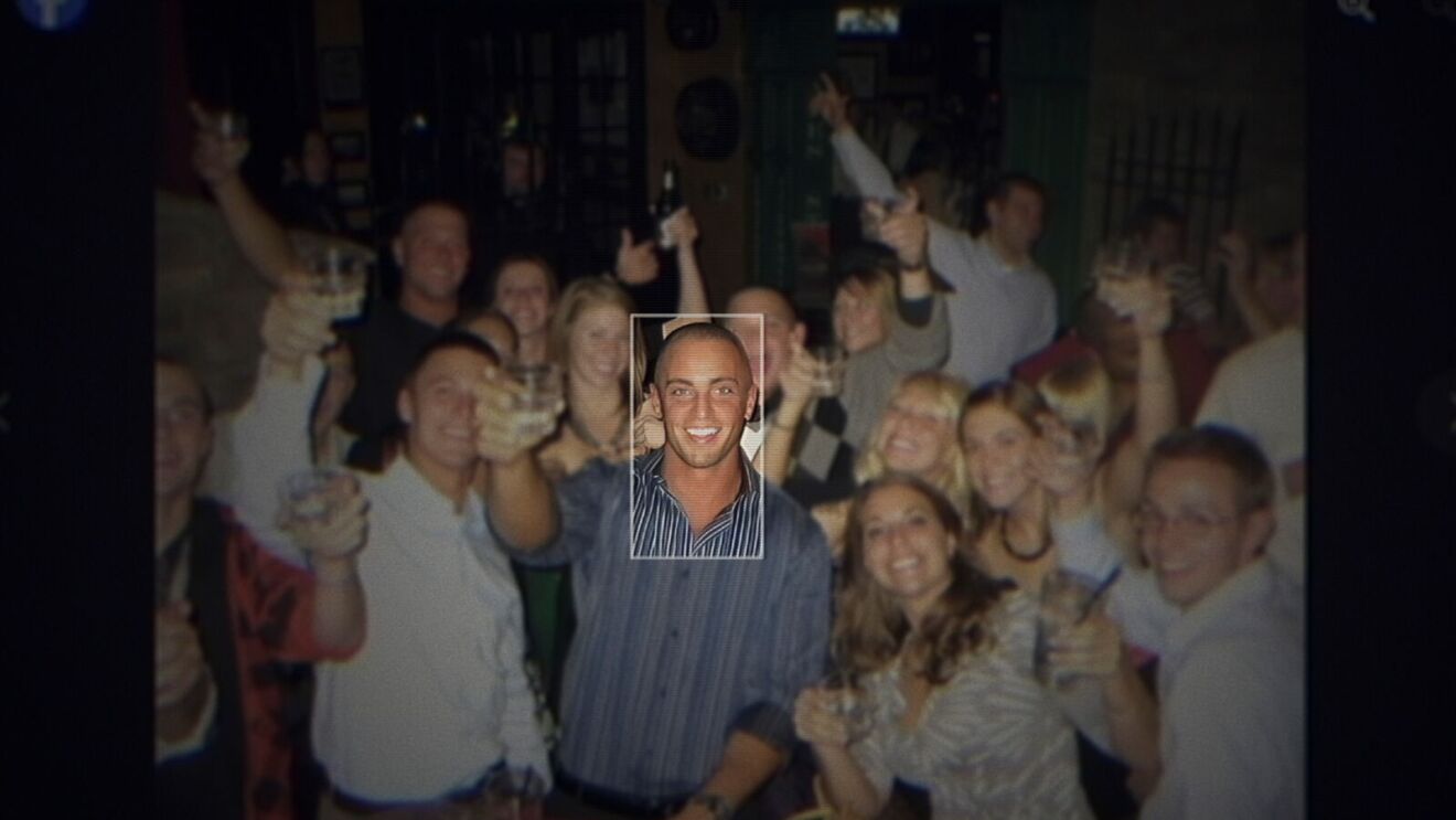 Zach Horwitz in the midst of a large group celebrating at a bar
