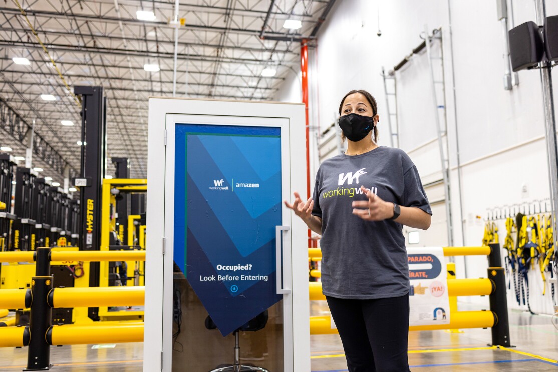 An image of an Amazon employee in a fulfillment center demonstrating how WorkingWell works.