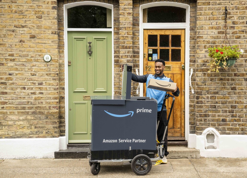 A man using the Amazon on-foot delivery pushcart next to a customer's doorstep