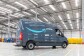 Delivery Service Partner (DSP): la nueva iniciativa de Amazon ayuda a que sus empleados inicien su propia compañía de reparto. Dentro de un centro logístico aparece una furgoneta de color gris con el logo de la sonrisa en azul y la palabra Prime en blanco. 