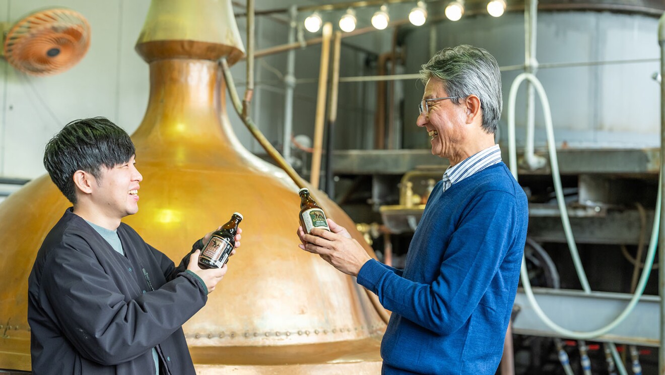 ビール瓶を手に会話をしている男性2人。そのうち一人は嶌田さん