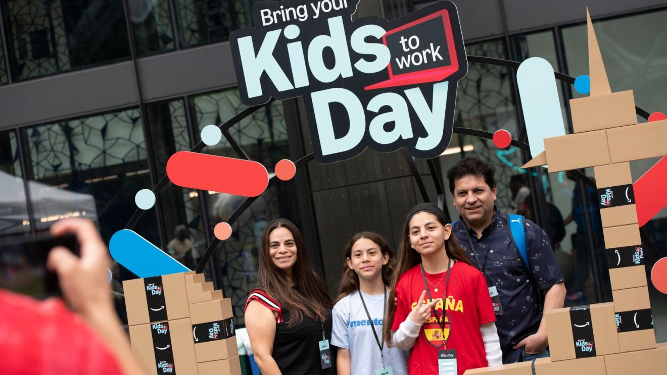 Family posing at Bring Your Kids to Work Day event with cardboard building decorations