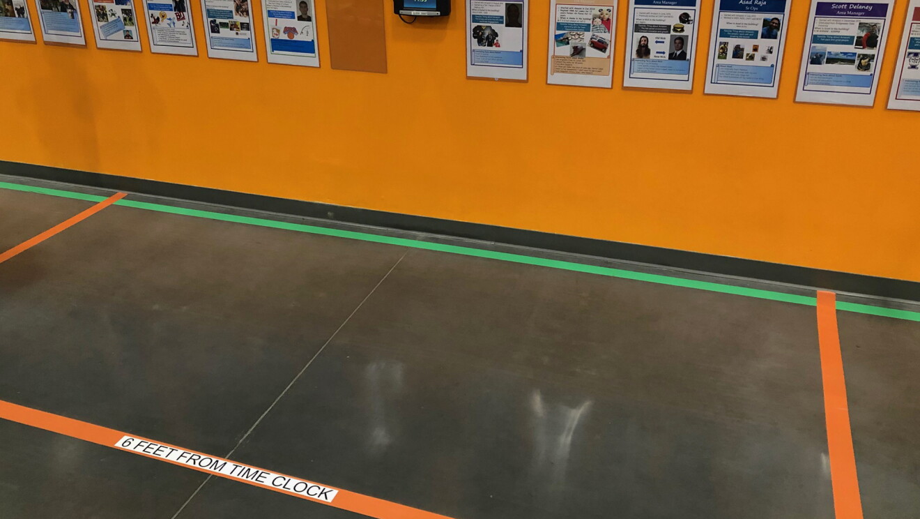 Zaklejone linie na podłodze w centrum logistycznym Amazon, aby zachęcić do dystansu społecznego wśród współpracowników.